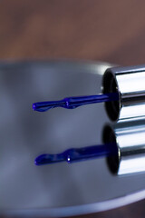 Brush with blue nail polish on mirror