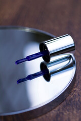 Brush with blue nail polish on mirror