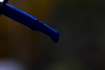 A drop of blue lacquer on a brush close-up