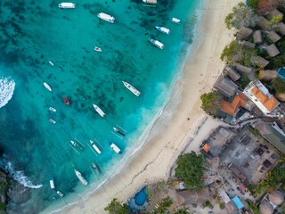 Aerial view of a coastal town with a sandy beach and boats in a bay