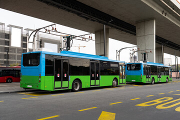 Electric buses at a stop are charging by pantograph © scharfsinn86