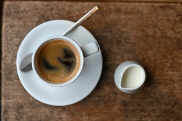 Top view of a cup of fresh hot espresso coffee and milk on a table