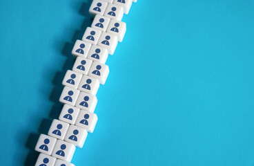 A chain of blocks of workers on a blue background. Place for text. Copyspace. Help wanted. Hiring new employees for vacancies. Human resources and work force. Staffing and recruiting candidates