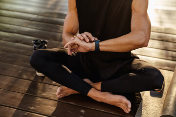 Young white man using smartwatch during yoga practice