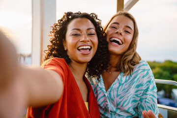 Selfie of two young beautiful enthusiastic girls on Ferris wheel