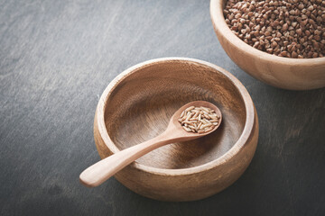 World food crisis concept. Empty and full old plate with buckwheat on a dark gloomy background....