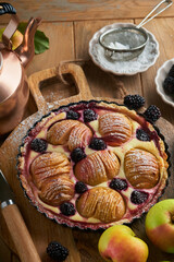 Apple pie. Apple and blackberries cake or pie decorated sugar powder on old wooden table. Delicious dessert for autumn or winter dinner. Autumn pastry dessert. Soft focus.