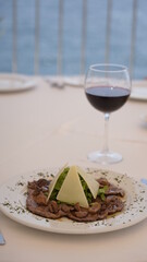 grilled meat presentation on a white plate and wine