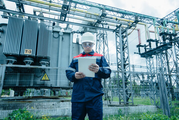 An energy engineer inspects the modern equipment of an electrical substation before commissioning. Energy and industry. Scheduled repair of electrical equipment.