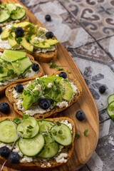 Vegetarian sandwich with microgreens on a wooden board, beautiful serving on a bright background