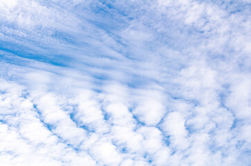 White cumulus clouds against blue sky. Atmospheric phenomena.	