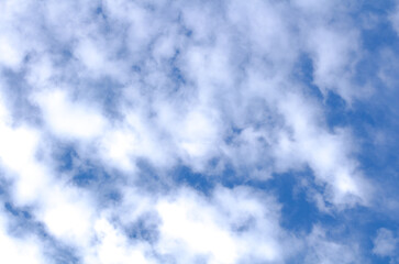 White cumulus clouds against blue sky. Atmospheric phenomena.	