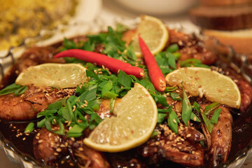 shrimp in soy sauce with lemon and red pepper sprinkled with sesame seeds.