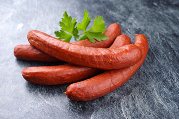 Traditionelle rohe bayrische scharfe Bratwurst mit Chili angeboten als close-up auf rustikalen grauen Board und Petersilie mit Textfreiraum 