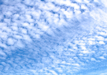 White cumulus clouds against blue sky. Atmospheric phenomena.	