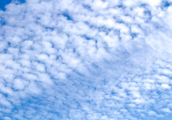 White cumulus clouds against  blue sky. Atmospheric phenomena.
