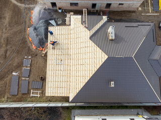 Aerial view of construction worker install new roof, Roofing tools and new roofs with Metal Sheet.