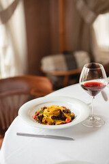 Appetizing Italian pasta with duck meat on a light background. Beautiful serving. Exquisite presentation of food.