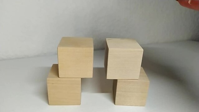 Math count for addition 4+1=5
A man builds a structure out of wooden blocks, stacking wooden blocks by hand. Business concept for success growth process.
