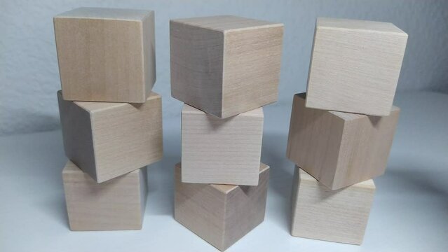 Math count for addition 8+1=9
A man builds a structure out of wooden blocks, stacking wooden blocks by hand. Business concept for success growth process.
