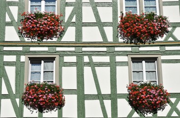 Half Timbered Frame Traditional Central European House with Green Painted Timber and Flowers under Windows