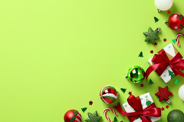 Merry Christmas and Happy New Year background. Gift boxes, baubles, Xmas decorations, confetti on pastel green background. Flat lay, top view, copy space.