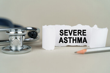 On a gray background, a stethoscope, a pencil and a paper plate with the inscription - Severe asthma