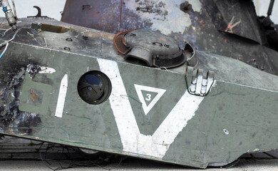 Obraz na płótnie Canvas War in Ukraine. Destroyed tank with a torn off turret with a V on it. Broken and burned Russian tanks. Designation sign or symbol in white paint on the tank. Destroyed military equipment.