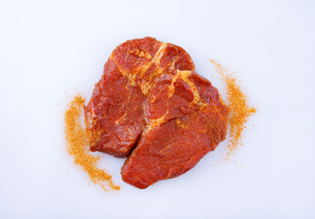 Traditionelles rohes gewürztes Nackensteak vom Schwein zubereitet für eine Sommer Grillparty angeboten als close-up auf einem weißen Board mit Textfreiraum