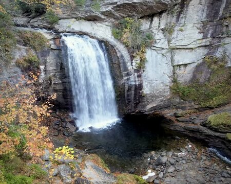 Looking Glass Falls waterfall near Brevard North Carolina surrounded by rock cliffs and a forest with autumn colors. Landscape with nobody in it. 