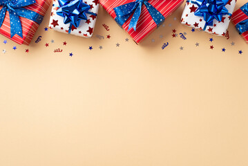 Obraz premium Forth of July celebration concept. Top view photo of present boxes in national flag colors and confetti on isolated beige background with blank space