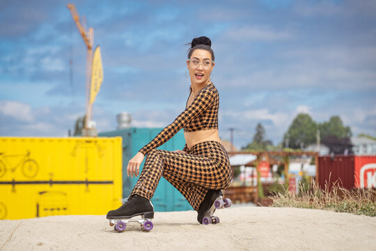 Stylish Asian woman outside at a colorful park playing with roller skates