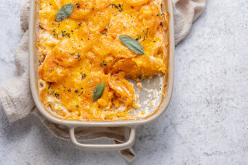 Savory Sweet potato gratin with cream and cheddar cheese in baking dish
