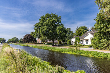 Street view of farm houses along Jonkersvaart neighborhood in municipality Westerkwartier in...