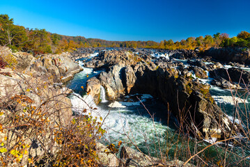 fast mountain river flows among high rocks. Autumn landscape of a wide mountain river on a sunny day.