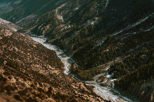 View of green forest meets brown  bushes with Khangsar river in the middle, from the way to Tilicho Base Camp, Annapurna Circuit Trek, Nepal