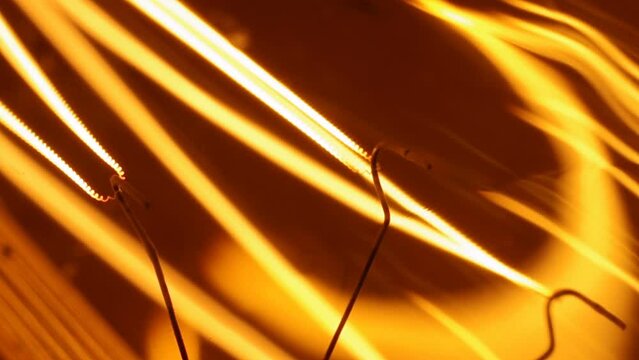 Macro shooting on a working incandescent filament attached to wires inside a vintage Edison light bulb.