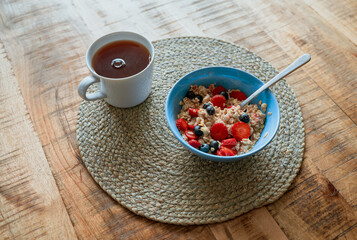 cup of tea with berries and cinnamon and also oats for breakfast