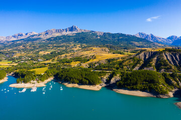 Serene summer landscape of Lake Serre-Poncon, artificial lake surrounded by French Alps,...