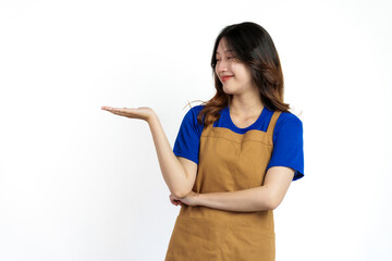 Palm up, Cheerful young pretty asian woman blue t-shirt and apron coffee owner isolated on white background.