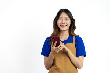 Cheerful young pretty asian woman blue t-shirt and apron coffee owner isolated on white background. Receive orders from the mobile app