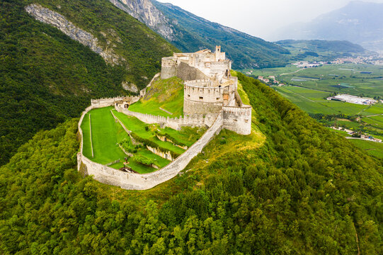 Scenic aerial view of large fortified Beseno castle on top of hill in Besenello, Italy