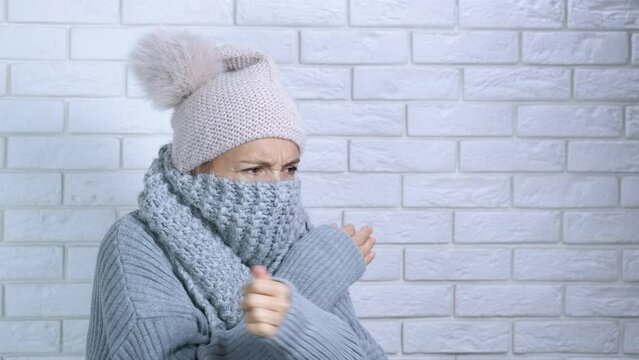 Apartment without central heating. A female suffer from cold in her cool apartment in winter. A concept of trouble with central heating during inflation time.