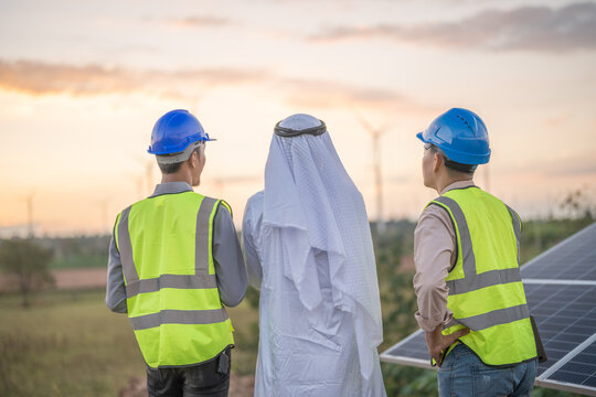 Arab Busines And Engineer Man Inspects Construction Of Solar Cell Panel Or Photovoltaic Cell By Electronic Device. Industrial Renewable Energy Of Green Power.