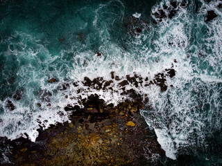 Oceano chocando con las rocas de la orilla con dron