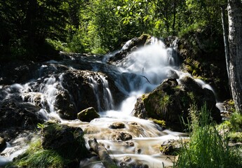 Long exposure shot of a beautiful waterfall flowing over rocks on a sunny day