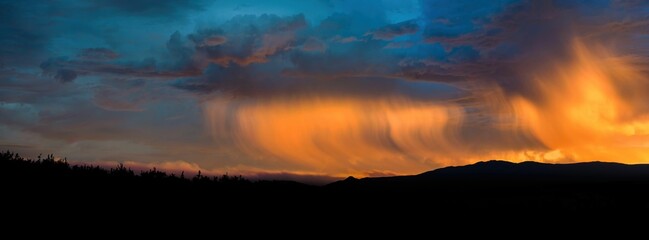 Panoramic shot of a beautiful sunset with a cloudy sky over a landscape