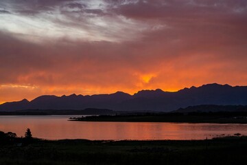 Beautiful shot of a sunset over a lake and mountains