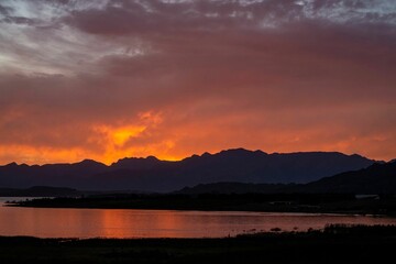 Beautiful shot of a sunset over a lake and mountains