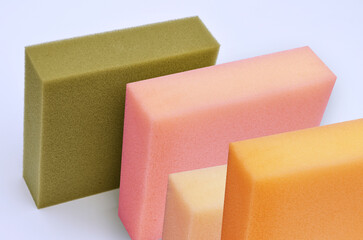 square pieces of thick spongy foam in brown, pink, cream and orange colors on a white background. a bunch of colorful materials